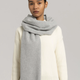 A model wears a gray Asket cashmere scarf